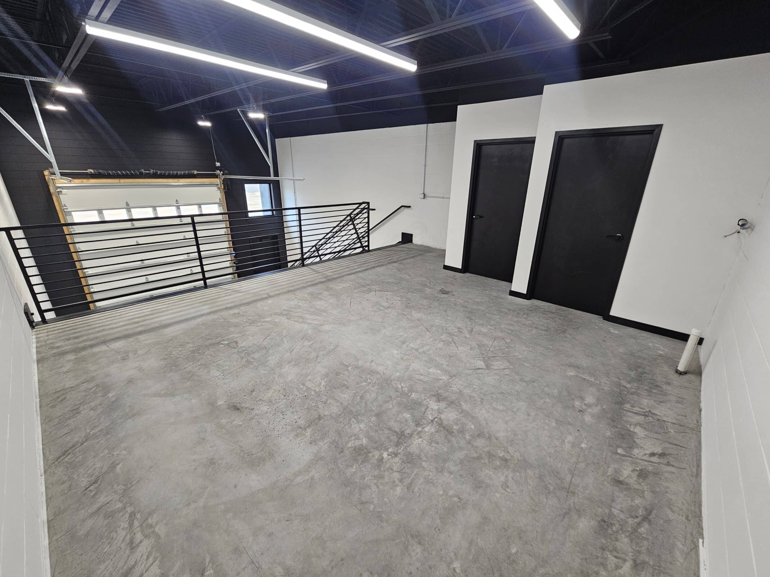 Mezzanine and entry doors in a Hide Out garage suite before any owner build-out