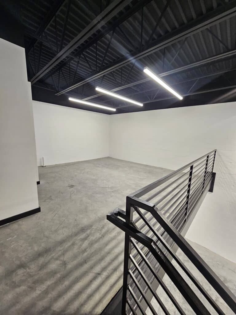 The open floor and mezzanine edge of a Hide Out garage suite before build-out