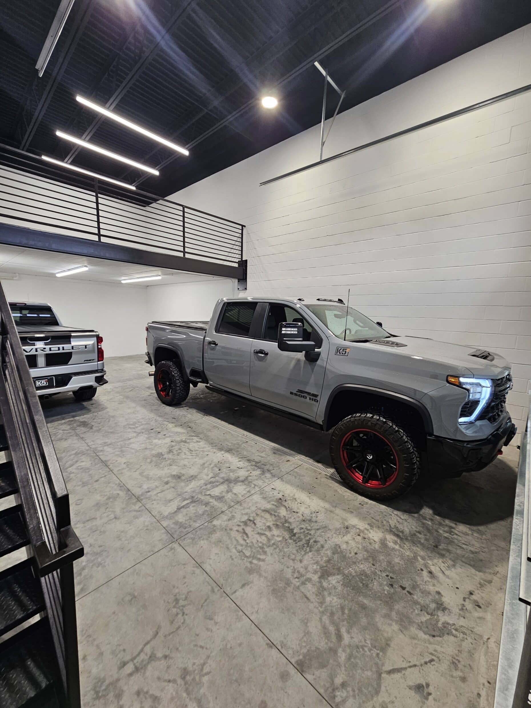 A pickup truck parked beneath the mezzanine in a Hide Out garage suite