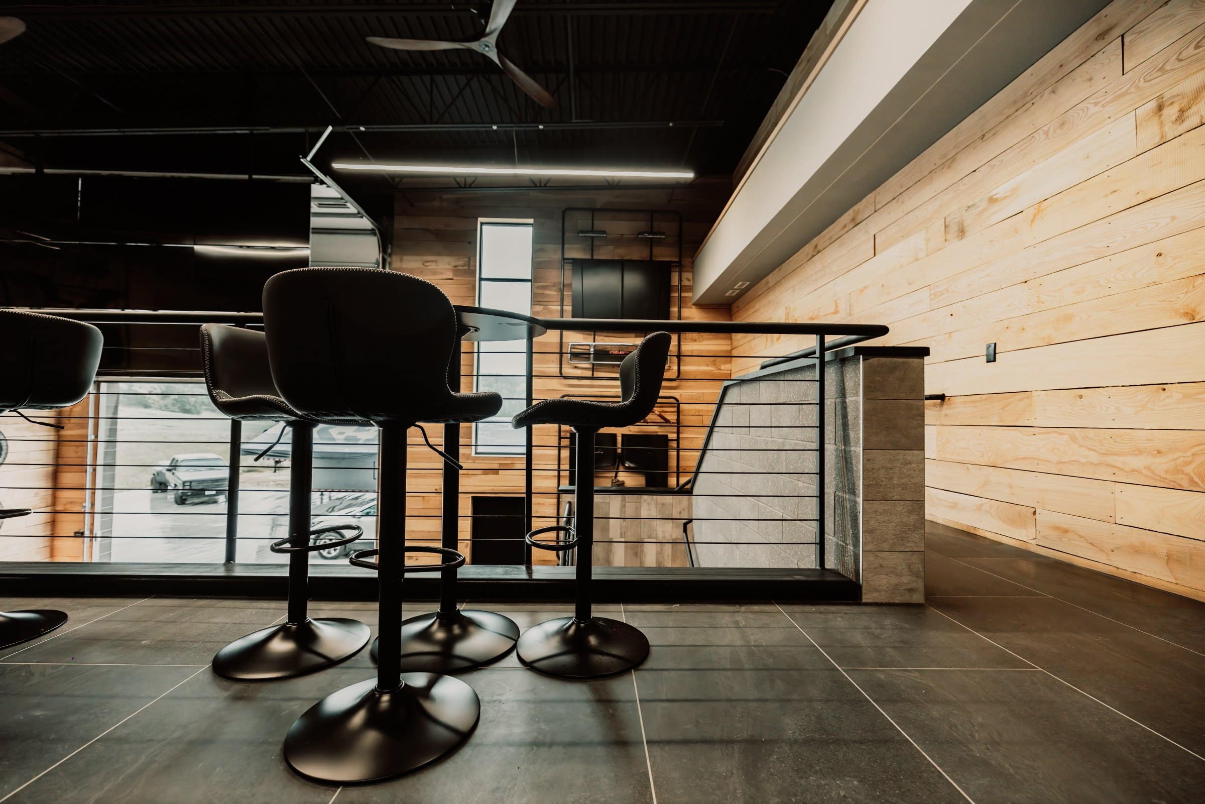 Bar stools along the mezzanine bar of a finished man cave suite at The Hide Out